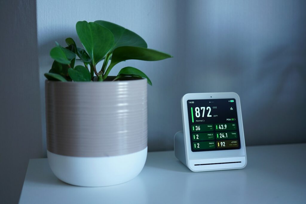 Indoor air quality monitor on a desk — the form factor of modern continuous radon detectors.